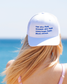 Blonde woman in Greece wears vintage summer hat with witty quote